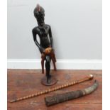 An ethnic carved wooden figure of tribesman with a dead animal over his knee, together with a carved