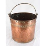 A copper coal/log bucket with riveted detailing and brass handle, 31cm high