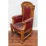An oak Masonic Master's chair with dark red upholstered back, seat and arm rests, shaped crest
