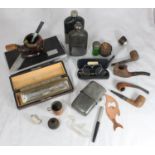 A collection of pipes including one with a 'negro' head together with three various hip flasks,