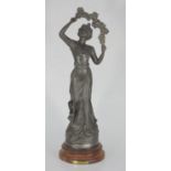 A patinated spelter figure 'Primevere', raised on turned wooden pedestal base, 43cm tall