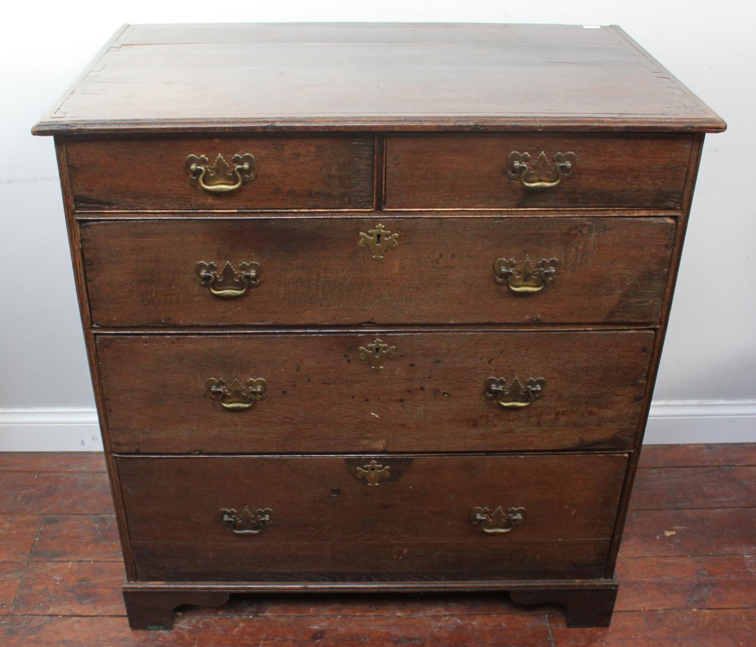 An early 18th century stained oak chest of two short and three long graduated drawers, later brass