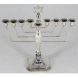 Of Judaic interest. A silver nine-branch menorah topped with a Star of David, on leaf shaped support