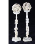 A pair of Chinese Ivory puzzle balls on figural stands, c1900, 25cm high
