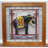 A large oak-framed stained glass panel featuring an elephant, 118x118cm