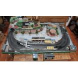 An '00' gauge electric train layout, with various buildings, platforms, tunnel, house, shops and