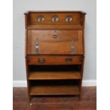 A 19th century Arts & Crafts stained oak bureau in the manner of Liberty & Co, with three-quarter