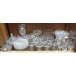 A shelf of assorted mixed glassware comprising stemmed dessert bowls, plates, a lemonade set and a