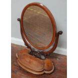 A Victorian stained mahogany oval toilet mirror, the oval mirror in scrollwork frame, the shaped