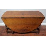 A 17th century stained oak oval drop-leaf gate-leg dining table, with opposing frieze drawers,