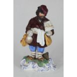 A Russian ceramic figure of a 'Bagel-Seller' in the style of the Gardner factory, raised on scrolled