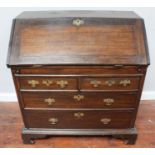 George III stained oak bureau with fall-front enclosing cupboards drawers and pigeonholes and