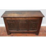 A 17th century oak coffer, with three geometrically carved panels to the front, on stile supports,