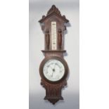 An oak aneroid barometer with foliate and gothic arch carvings, white circular dial, approx. 92cm