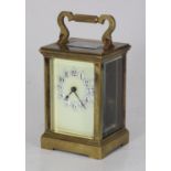 A brass carriage clock, the top with platform escapement, the ivory coloured dial with Arabic