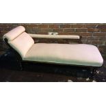 An Edwardian carved oak chaise lounge with beige upholstery and shaped carved and upholstered back