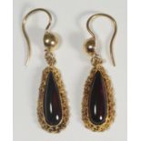 A pair of 15ct gold filigree drop earrings, set with pear shaped cabochon garnets, circa 1870 (