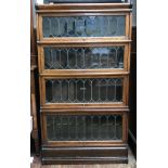 A stained oak four-section Globe Wernicke with glazed astragal doors, raised on shaped plinth