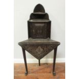 A 19th century stained and carved oak corner table with raised back and small cupboard, together