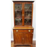 A George III mahogany glazed bookcase cupboard, with astragal glazed doors enclosing adjustable