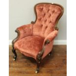 A Victorian stained walnut armchair with rouge velvet deep-button upholstery