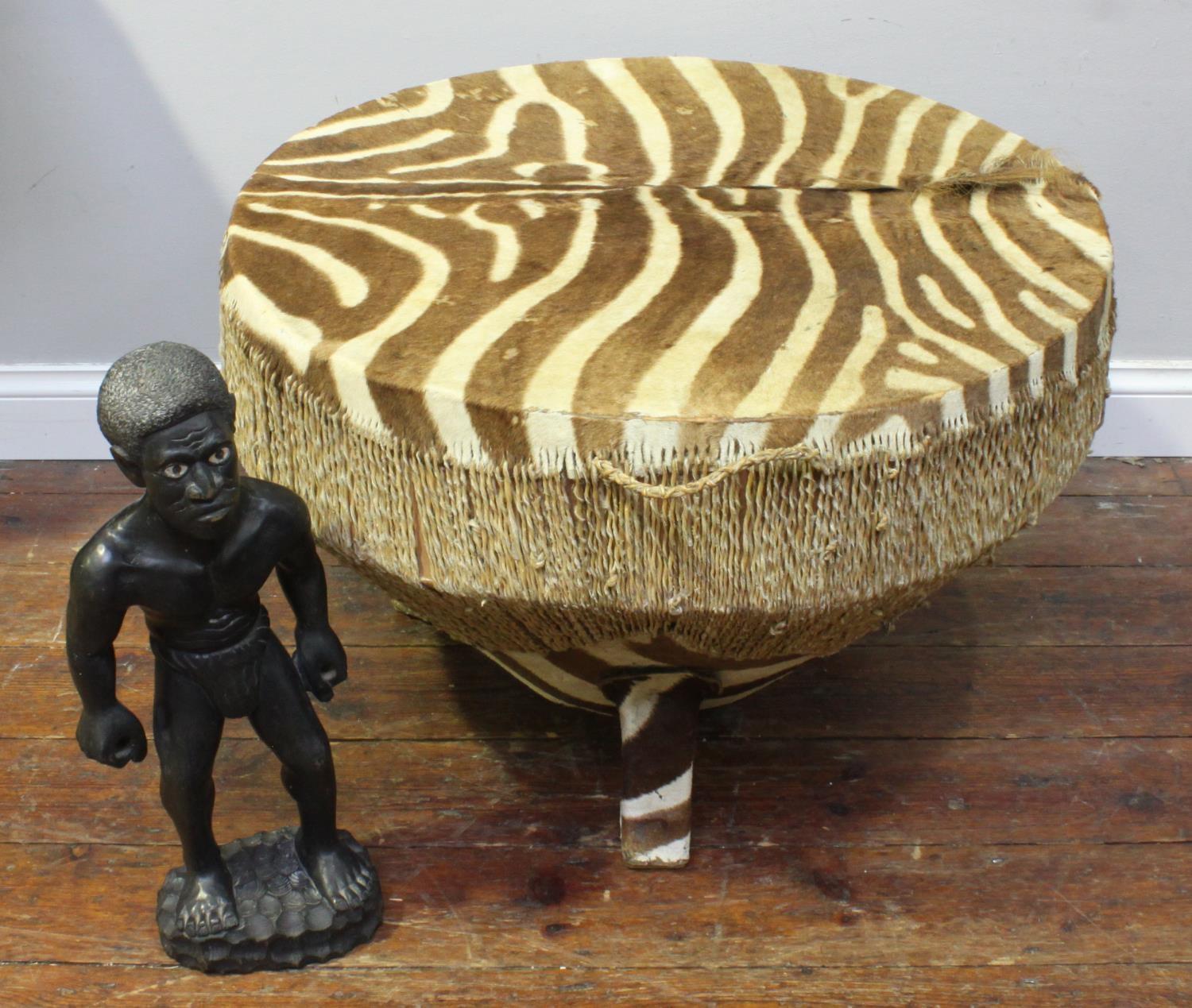 A large antique zebra hide floor drum table believed to be early 20th century with twisted rawhide