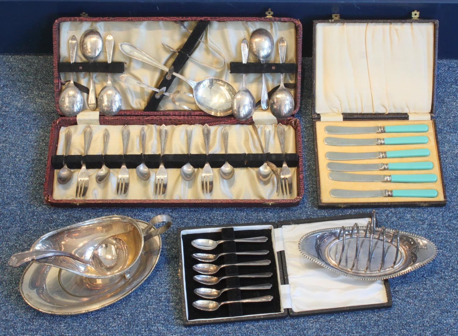 A quantity of silver-plated items including a cased cutlery set, gravy boat, serving spoon, toast