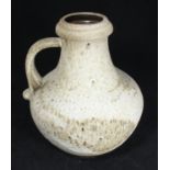 A West German pottery jug of globular form with cylindrical neck, finished in a mottled brown and