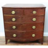 A 19th century bow-front mahogany chest of two short and three long graduated drawers, oval brass