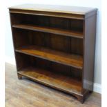 An Edwardian stained walnut open bookcase, with two adjustable shelves, shaped bracket feet, 109cm