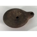 A terracotta oil lamp, probably Roman, of typical form and decorated with geometric designs, 8cm