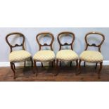 A set of four Victorian walnut balloon back standard chairs, with cream and gold fabric