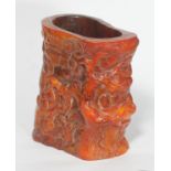 A Chinese horn libation cup, carved with laughing figures amongst trees and buildings, approx.