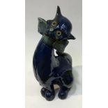 A C.H. Brannam for Bobby & Co Ltd model of a stylised seated cat, modelled with glass eyes and