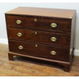 A 19th century stained mahogany chest of three long drawers, with brass escutcheons and oval