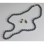 A black-tinted cultured pearl necklace with 9ct gold globular safety clasp, together with a pair