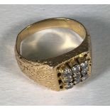 A yellow metal (tests as 18ct gold or above) gents ring, the top set with a square of nine diamonds,