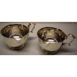 A pair of silver West Country sauceboats, the circular bowls with a moulded lip and cast scrolling