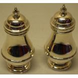 A pair of silver baluster pepper mills, with girdle moulding, the domed covers with baluster
