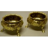 A pair of early Victorian silver gilt circular salts, engraved a crest with motto and chased with
