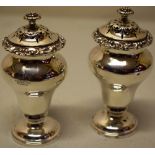 A pair of early Victorian silver waisted peppers, engraved a crest gilded inside, the scroll borders