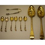 A pair of silver gilt berry spoons, the differing repousse bowls with a pineapple and melons, the