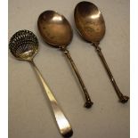 A pair of antique continental spoons, the oval bowls with cast scroll scale terminal handles and a