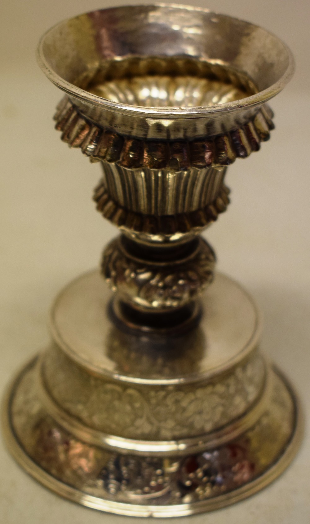 A nineteenth century silver pricket candlestick, the ribbed vase shape holder with a foliage