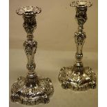 An attractive pair of Victorian silver candlesticks, of an earlier style, crested with foliage