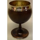 A late eighteenth century carved coconut goblet, the etched bowl with unmarked silver rim and