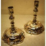 A pair of Augsburg mid eighteenth century silver rococo candlesticks, swirl fluted repousse