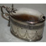 A George III oval silver mustard pot, the sides engraved tassellated swags beneath a pierced fret