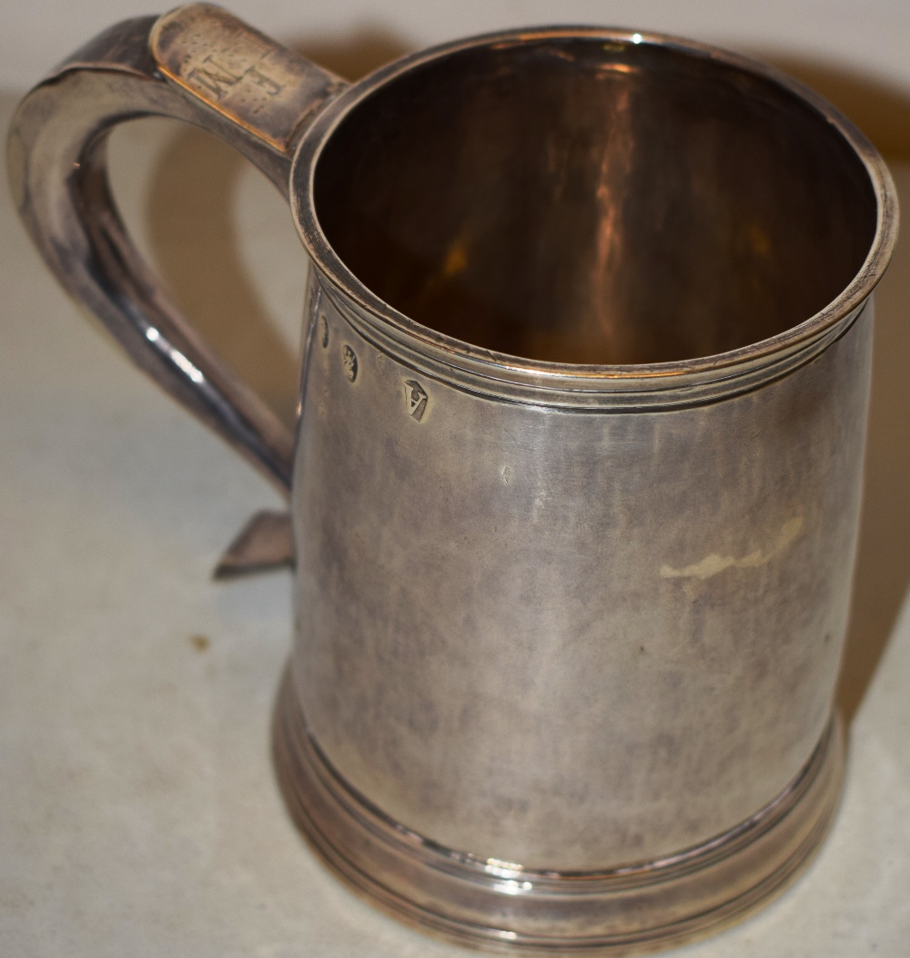 A George 1st Britannia standard silver mug, with a hollow capped scroll handle, engraved initials