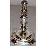 An early George II silver taperstick, the spool shape holder on a knopped facetted baluster stem, to
